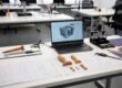 Custom non-standard product prototypes with technical drawings, 3D design on laptop and precision tools on modern studio table – challenges finding specialized manufacturers for niche LGBTQ adult products