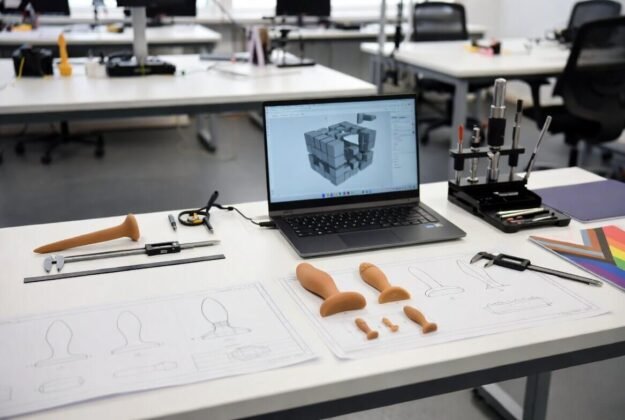 lKT2E (1) (1) Custom non-standard product prototypes with technical drawings, 3D design on laptop and precision tools on modern studio table – challenges finding specialized manufacturers for niche LGBTQ adult products