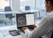 Product developer reviewing prototype cost breakdown and 3D model on laptop with budget documents